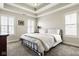 Relaxing bedroom showcasing a metal bed frame, tray ceiling and light-filled windows at 13018 Deerstyne Green St, Carmel, IN 46032