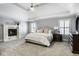 Main bedroom with a fireplace, large windows with lots of natural light, and tray ceiling at 13018 Deerstyne Green St, Carmel, IN 46032