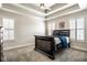 Spacious bedroom featuring tray ceilings, bright windows, and a sleek black bed frame at 13018 Deerstyne Green St, Carmel, IN 46032