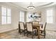 Inviting dining room with hardwood floors, custom lighting, a tray ceiling, and neutral decor at 13018 Deerstyne Green St, Carmel, IN 46032