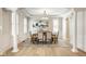 Elegant dining room featuring hardwood floors, wainscoting, large windows, and a stylish chandelier at 13018 Deerstyne Green St, Carmel, IN 46032