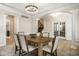 Spacious dining room featuring hardwood floors, a tray ceiling, stylish lighting, and a view of the staircase at 13018 Deerstyne Green St, Carmel, IN 46032
