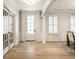 Bright foyer featuring hardwood floors, elegant trim, a glass-paneled front door, and French doors at 13018 Deerstyne Green St, Carmel, IN 46032