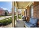 Relaxing front porch featuring comfortable seating, views of the neighborhood, and a brick exterior at 13018 Deerstyne Green St, Carmel, IN 46032