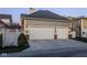 Attached two car garage featuring carriage doors, brick accents, outdoor lighting and a basketball hoop on a manicured lawn at 13018 Deerstyne Green St, Carmel, IN 46032