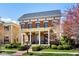 Charming brick two-story home with a covered front porch, classic design elements and manicured landscaping at 13018 Deerstyne Green St, Carmel, IN 46032