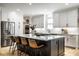Bright kitchen with stainless steel appliances, white cabinets, large island with bar seating, and wood floors at 13018 Deerstyne Green St, Carmel, IN 46032