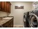 Convenient laundry room equipped with cabinetry, sink, and modern washer and dryer units at 13018 Deerstyne Green St, Carmel, IN 46032