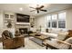 Comfortable living room featuring a fireplace, ceiling fan and natural light at 13018 Deerstyne Green St, Carmel, IN 46032