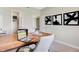 Bright office area with a wooden desk, modern art, and an open closet for an organized, efficient workspace at 16959 Sandhurst Pl, Westfield, IN 46074
