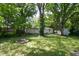 Landscaped backyard featuring lush greenery, a firepit, and plenty of space at 1740 Haynes Ave, Indianapolis, IN 46240