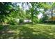 Lush backyard with mature trees, a patio, and a fire pit at 1740 Haynes Ave, Indianapolis, IN 46240