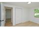 Bedroom with doorway, closet, light-colored walls, wood floors, and bright window with a view of the outdoors at 1740 Haynes Ave, Indianapolis, IN 46240