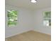 Bedroom featuring light-colored walls, wood floors, and two bright windows with a view of the outdoors at 1740 Haynes Ave, Indianapolis, IN 46240