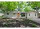 Charming ranch home with light-colored siding, a modern peach door, and a beautifully landscaped front yard at 1740 Haynes Ave, Indianapolis, IN 46240