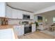 Modern kitchen open to the living room, featuring white cabinets, and stainless steel appliances at 1740 Haynes Ave, Indianapolis, IN 46240