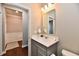Compact half bath with modern vanity, decorative mirror, and hardwood floors at 2186 Chick Evans Way, Westfield, IN 46074