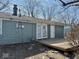 Rear exterior of the house with a wooden deck and some minimal landscaping at 2308 W Surrey Dr, Muncie, IN 47304