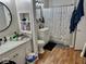 Well-lit bathroom featuring sleek fixtures, shelving, and a shower with curtain at 2308 W Surrey Dr, Muncie, IN 47304