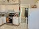 Kitchen has white cabinets, tile flooring, stainless steel stove, and entry to the living room at 2308 W Surrey Dr, Muncie, IN 47304