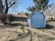 Backyard view of blue shed with wooden fence and mature trees in background at 2308 W Surrey Dr, Muncie, IN 47304