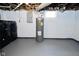 Basement with concrete walls and grey floor, showcasing the utility area, including a water heater and laundry at 2528 S New Jersey St, Indianapolis, IN 46225