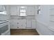 Kitchen with white cabinets, white appliances and wood-look floors at 2528 S New Jersey St, Indianapolis, IN 46225