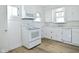 Kitchen with white cabinets, white appliances and wood-look floors at 2528 S New Jersey St, Indianapolis, IN 46225