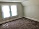 Bedroom with grey walls, plush carpeting, and a bright double hung window at 302 S Randolph St, Indianapolis, IN 46201