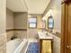 Bathroom featuring a separate tub, double sinks, two mirrors, and natural lighting from the window at 3040 Old Morgantown Rd, Martinsville, IN 46151