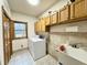 Laundry room with washer, dryer, tiled floors, cabinet space, sink, window, and utility sink at 3040 Old Morgantown Rd, Martinsville, IN 46151