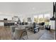 Bright, open-concept living room with large windows, modern furniture, and seamless flow into the kitchen at 3548 Planck Cir, Danville, IN 46122