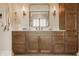 Elegant bathroom featuring dark wood cabinetry, double sinks, and marble countertops, complemented by decorative mirrors at 3787 Cherwell Dr, Zionsville, IN 46077