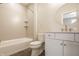 This bathroom features white cabinets, a round modern mirror, tiled floors, and a tiled shower and bathtub at 3787 Cherwell Dr, Zionsville, IN 46077