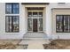 Elegant front entrance with dark trim windows and a custom wood door at 3787 Cherwell Dr, Zionsville, IN 46077