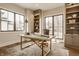 Bright home office with large windows, built-in shelving, marble desk, and hardwood flooring at 3787 Cherwell Dr, Zionsville, IN 46077