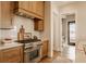 Well-equipped kitchen with stainless steel stove, custom cabinets, and hardwood flooring at 3787 Cherwell Dr, Zionsville, IN 46077