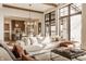 Bright, open living room with a large sofa, windows, and open access to the kitchen and dining area at 3787 Cherwell Dr, Zionsville, IN 46077