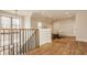 Second floor living area with hardwood flooring, staircase, large window, and cozy seating at 3787 Cherwell Dr, Zionsville, IN 46077
