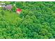 Birds-eye view showcases a home and outbuilding amidst a sea of verdant green trees at 4590 Turkey Track Rd, Martinsville, IN 46151