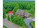 Aerial shot of home with large red workshop, and an ample paved driveway, surrounded by dense trees at 4590 Turkey Track Rd, Martinsville, IN 46151