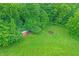 Secluded backyard with a firepit surrounded by benches and a red outbuilding in a wooded area at 4590 Turkey Track Rd, Martinsville, IN 46151