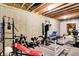 Basement workout space with gym equipment and exposed ceiling and brick accent wall at 4590 Turkey Track Rd, Martinsville, IN 46151