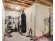 Workout area in basement with exposed ceiling, white brick accent wall and workout equipment at 4590 Turkey Track Rd, Martinsville, IN 46151