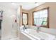 Bathroom features a glass enclosed shower and separate tub under a large window at 4590 Turkey Track Rd, Martinsville, IN 46151