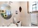Cozy bathroom with round mirror, toilet, sink and a window at 4590 Turkey Track Rd, Martinsville, IN 46151