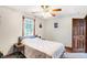 Bedroom featuring neutral tones, a ceiling fan, a window with blinds, and a view into the backyard at 4590 Turkey Track Rd, Martinsville, IN 46151
