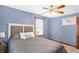 Bedroom featuring blue walls, a ceiling fan, a large bed, and a single window with natural light at 4590 Turkey Track Rd, Martinsville, IN 46151