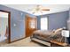 Bedroom with blue walls, a ceiling fan, a double door closet, a bed, and a window with a view at 4590 Turkey Track Rd, Martinsville, IN 46151