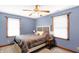 Bedroom with blue walls, a ceiling fan, two windows, a bed, and a small bedside table with lamps at 4590 Turkey Track Rd, Martinsville, IN 46151